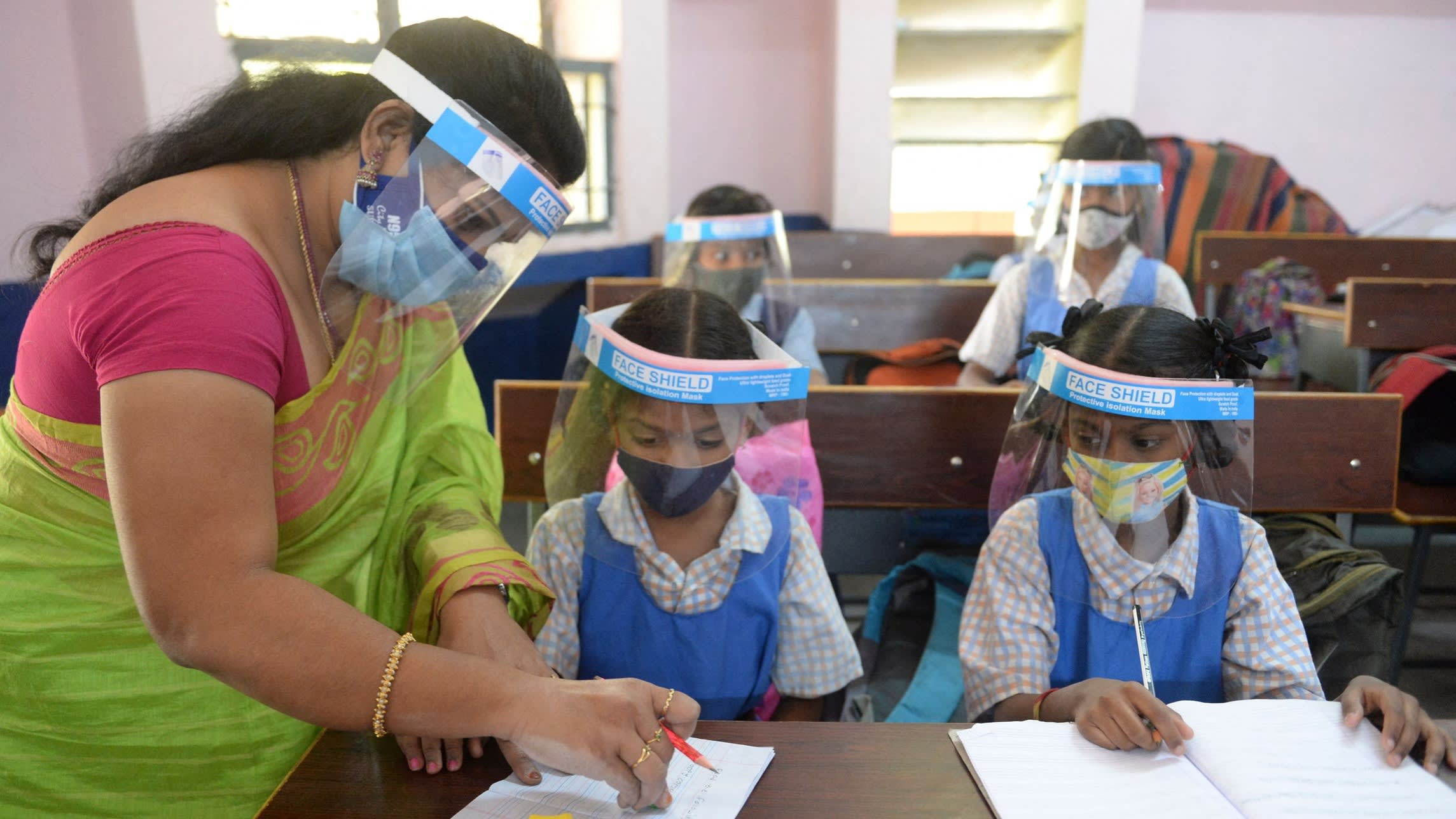 Students wearing facemasks and face shields attend a class after the reopening of schools in Hyderabad, India, in February last year