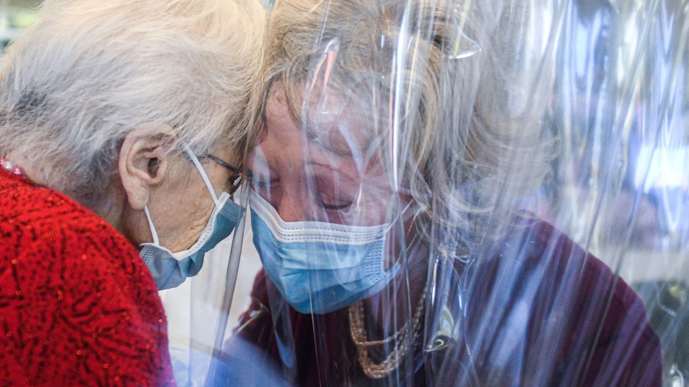 A mother and daughter hug through plastic sheeting at a care home in Italy during the pandemic. We risk taking steps back if the commitments to govern innovation do not reflect the values of health for all
